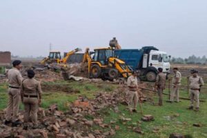 उधमसिंह नगर, 5 मई 2025 (समय बोल रहा ): उत्तराखंड के उधमसिंहनगर जिले में चर्चित पूजा मंडल हत्याकांड के मुख्य आरोपी मुश्ताक के सितारगंज स्थित गौरीखेड़ा गांव में बने अवैध मकान को प्रशासन ने भारी पुलिस बल की मौजूदगी में जेसीबी चलवाकर ध्वस्त कर दिया। यह कार्रवाई जिलाधिकारी नितिन भदौरिया और वरिष्ठ पुलिस अधीक्षक मणिकांत मिश्रा के सख्त निर्देश पर की गई। प्रशासन की यह सख्त कार्रवाई हत्या जैसे जघन्य अपराधों के खिलाफ "जीरो टॉलरेंस" की नीति को दर्शाती है। स्थानीय प्रशासन और पुलिस की इस संयुक्त कार्रवाई की अब सोशल मीडिया पर भी जमकर सराहना हो रही है। अवैध कब्जे पर बना था मकान प्रशासन द्वारा दी गई जानकारी के अनुसार, जिस जमीन पर मुश्ताक और उसके पिता अली अहमद का मकान बना था, वह जमीन अनुसूचित जाति के एक व्यक्ति मथुरा प्रसाद के नाम पर दर्ज थी। मुश्ताक के पिता अली अहमद ने इस जमीन पर वर्षों पूर्व अवैध कब्जा कर लिया था और वहीं पक्का मकान बना लिया था जिसमें दोनों बाप-बेटा रह रहे थे। प्रशासन ने इस अवैध निर्माण को लेकर पहले ही अली अहमद को नोटिस जारी किया था, लेकिन अली अहमद ने न तो जवाब दिया और न ही कोई कानूनी दस्तावेज प्रस्तुत किए। इसके बाद प्रशासन ने कड़ी कार्रवाई का निर्णय लिया और रविवार सुबह इस मकान को जेसीबी मशीन से ढहा दिया गया। हत्या का वीभत्स मामला गौरतलब है कि यह मामला 2 मई को उस समय सामने आया जब खटीमा के नदन्ना नहर में एक सिर कटी लाश बरामद हुई। जांच में मृतका की पहचान नानकमत्ता की पूजा मंडल के रूप में हुई, जो पिछले पांच महीनों से लापता थी और जिसकी गुमशुदगी की रिपोर्ट गुरुग्राम (हरियाणा) में दर्ज थी। पूजा मंडल के हत्यारोपी मुश्ताक को हरियाणा पुलिस की सहायता से उत्तराखंड के सितारगंज से गिरफ्तार किया गया। पुलिस जांच में सामने आया कि मुश्ताक और पूजा लंबे समय से लिव-इन रिलेशनशिप में थे। लेकिन 2 नवंबर 2024 को मुश्ताक ने किच्छा की एक युवती से निकाह कर लिया जिससे पूजा आहत हुई और दोनों के बीच लगातार विवाद बढ़ने लगा। ‘सर तन से जुदा’ की वीभत्स घटना पुलिस के अनुसार, मुश्ताक ने 16 नवंबर 2024 को पूजा को रास्ते से हटाने का मन बना लिया और एक नृशंस साजिश के तहत उसकी हत्या कर दी। उसने पूजा का सर धड़ से अलग कर शव को खटीमा के नदन्ना नहर में फेंक दिया। पुलिस ने मुश्ताक की निशानदेही पर पूजा के शव का धड़ बरामद कर लिया है, लेकिन उसका सिर अभी तक नहीं मिल पाया है। गोताखोरों की टीम बीते कई दिनों से नहर में सर्च ऑपरेशन चला रही है। सख्त संदेश: अपराधियों के लिए जगह नहीं प्रशासन द्वारा आरोपी के अवैध मकान पर की गई कार्रवाई को कानून व्यवस्था का कड़ा संदेश माना जा रहा है। जिलाधिकारी नितिन भदौरिया और एसएसपी मणिकांत मिश्रा ने कहा कि अपराध करने वालों के लिए जिले में कोई जगह नहीं है। इस तरह की कार्रवाई आगे भी जारी रहेगी, ताकि समाज में अपराध के प्रति भय और न्याय के प्रति विश्वास बना रहे। सोशल मीडिया पर समर्थन इस कार्रवाई के बाद स्थानीय नागरिकों और सोशल मीडिया यूज़र्स ने प्रशासन की कार्रवाई को लेकर जमकर समर्थन जताया है। लोगों ने कहा कि इस तरह की ठोस कार्रवाई से कानून का डर अपराधियों में बना रहेगा और पीड़ित परिवार को न्याय मिलने की उम्मीद भी मजबूत होगी। मुश्ताक की गिरफ्तारी पूजा मंडल हत्याकांड ने पूरे क्षेत्र को झकझोर कर रख दिया था। आरोपी मुश्ताक की गिरफ्तारी के बाद उसके अवैध मकान को ढहाना इस बात का प्रतीक है कि अपराध और अवैध कार्यों को कतई बर्दाश्त नहीं किया जाएगा। प्रशासन की इस त्वरित और सख्त कार्रवाई ने आम जनता में भरोसे की भावना को और मजबूत किया है।