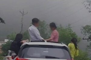 नैनीताल, 7 जुलाई, 2025 – (समय बोल रहा ) – उत्तराखंड के नैनीताल में सैलानियों की स्टंटबाजी का एक और खतरनाक वीडियो सोशल मीडिया पर तेजी से वायरल होते ही पुलिस प्रशासन हरकत में आ गया। ज्योलिकोट क्षेत्र में एक तेज़ रफ्तार चलती हरियाणा नंबर की कार से, उसमें सवार कुछ पर्यटक सनरूफ और खिड़कियों से बाहर झांककर जानलेवा तरीके से फोटो खिंचवाते हुए नजर आए। इस खतरनाक स्टंट को देखकर सोशल मीडिया पर भारी नाराजगी फैल गई और आम लोगों ने नैनीताल पुलिस से तत्काल कार्रवाई की मांग की। पुलिस ने त्वरित कार्रवाई करते हुए न केवल चालान काटा, बल्कि भविष्य में ऐसी लापरवाही न करने की सख्त चेतावनी भी दी है। यह घटना एक बार फिर इस बात को रेखांकित करती है कि सोशल मीडिया पर लाइक्स बटोरने का जुनून किस हद तक लोगों की जान जोखिम में डाल रहा है। तेज रफ्तार कार, खतरनाक पोज़: वायरल वीडियो की पूरी कहानी वायरल वीडियो में साफ देखा जा सकता है कि एक हरियाणा नंबर की तेज रफ्तार कार ज्योलिकोट क्षेत्र से गुजर रही है। कार में सवार कुछ युवक और युवतियां, सनरूफ से बाहर निकलकर और खिड़कियों से आधा शरीर बाहर निकालकर खतरनाक तरीके से पोज दे रहे हैं। वे चलती गाड़ी में अपनी जान जोखिम में डालकर फोटो और वीडियो बना रहे थे, संभवतः सोशल मीडिया पर 'रील्स' या पोस्ट डालने के उद्देश्य से। इस तरह की हरकतें न केवल उनमें सवार व्यक्तियों के लिए बल्कि सड़क पर चल रहे अन्य वाहनों और पैदल यात्रियों के लिए भी बड़ा खतरा पैदा करती हैं। वीडियो के वायरल होते ही सोशल मीडिया प्लेटफॉर्म्स पर हजारों लोगों ने इस पर तीखी प्रतिक्रिया दी। गुस्साए यूजर्स ने इसे 'लापरवाही की हद' और 'पर्यटन स्थलों पर अराजकता' करार दिया। बड़ी संख्या में लोगों ने नैनीताल पुलिस और उत्तराखंड पुलिस को टैग करते हुए ऐसे गैर-जिम्मेदाराना व्यवहार के खिलाफ कड़ी कार्रवाई की मांग की। एसएसपी का त्वरित संज्ञान: तुरंत हुई चालानी कार्रवाई और काउंसलिंग नैनीताल जनपद के वरिष्ठ पुलिस अधीक्षक (एसएसपी) प्रह्लाद नारायण मीणा ने वायरल वीडियो का तुरंत संज्ञान लिया। उन्होंने मामले की गंभीरता को समझते हुए संबंधित वाहन और उसके चालक को तत्काल चिन्हित करने के निर्देश दिए। एसएसपी के निर्देशों पर हरकत में आई पुलिस टीम ने फुटेज के आधार पर वाहन नंबर का पता लगाया और हरियाणा नंबर की उस गाड़ी को ट्रेस कर लिया। पुलिस ने तत्परता दिखाते हुए वाहन चालक के खिलाफ चालानी कार्रवाई की। वाहन चालक पर मोटर वाहन अधिनियम के तहत निर्धारित धाराओं में जुर्माना लगाया गया। सिर्फ चालान तक ही बात नहीं रुकी, पुलिस ने कार में सवार परिवार के अन्य सदस्यों की भी काउंसलिंग की। इस काउंसलिंग का उद्देश्य उन्हें उनके गैर-जिम्मेदाराना व्यवहार के खतरों से अवगत कराना और भविष्य में ऐसी गलतियों को दोहराने से रोकना था। पुलिस के मुताबिक, पूछताछ के दौरान वाहन चालक ने अपनी गलती स्वीकार करते हुए पुलिस से माफी मांगी। उसने भविष्य में कभी भी ऐसी लापरवाही न करने का वादा भी किया। यह पुलिस की त्वरित और प्रभावी कार्रवाई का परिणाम था कि अपराधियों को भागने का मौका नहीं मिला और उन्हें अपनी गलती का एहसास भी हुआ। सड़क हादसों पर लगाम: एसएसपी के सख्त निर्देश और पुलिस की अपील नैनीताल जनपद में सड़क हादसों पर प्रभावी रोक लगाने के लिए एसएसपी प्रह्लाद नारायण मीणा ने सभी थाना प्रभारियों और यातायात पुलिस को सख्त निर्देश जारी किए हैं। इन निर्देशों के तहत, अब जिले में ड्रंक एंड ड्राइव (शराब पीकर गाड़ी चलाना), ओवरस्पीडिंग (तेज रफ्तार), रैश ड्राइविंग (लापरवाह ड्राइविंग) और स्टंटबाजी के खिलाफ एक विशेष और सघन अभियान चलाया जाएगा। पुलिस ऐसी किसी भी गतिविधि पर कड़ी नजर रखेगी जो सड़क सुरक्षा के लिए खतरा पैदा कर सकती है। नैनीताल पुलिस ने आम जनता, विशेषकर पर्यटकों से एक सख्त अपील जारी की है: "चलती गाड़ी में किसी भी तरह की स्टंटबाजी न करें।" "सनरूफ का मतलब खतरनाक पोज़ देना नहीं है। यह सुविधा यात्रियों के आराम और आनंद के लिए है, न कि जान जोखिम में डालकर स्टंट करने के लिए।" "सोशल मीडिया पर फोटो सेशन के चक्कर में अपनी और दूसरों की जान को खतरे में डालकर हादसे को न बुलाओ।" 'लाइक्स की भूख' और सड़क सुरक्षा: एक गंभीर चेतावनी यह घटना एक बार फिर इस कड़वी सच्चाई की ओर इशारा करती है कि सोशल मीडिया पर लाइक और फॉलोवर्स बटोरने की भूख, लोगों की अपनी और दूसरों की जान के लिए कितना बड़ा खतरा बन सकती है। पर्यटक स्थलों पर लोग अक्सर अपनी यात्रा को यादगार बनाने और सोशल मीडिया पर 'अलग' दिखने के लिए ऐसी खतरनाक हरकतें कर बैठते हैं, जो अंततः गंभीर दुर्घटनाओं का कारण बनती हैं। नैनीताल जैसे पर्यटन स्थल, जहां हर साल लाखों की संख्या में सैलानी आते हैं, यदि पर्यटक खुद ही नियमों को तोड़ने लगेंगे और खतरनाक स्टंट करेंगे, तो फिर दुर्घटनाओं से कैसे बचा जा सकेगा? यह एक गंभीर सवाल है जो पर्यटन स्थलों पर सुरक्षा व्यवस्था और पर्यटकों की नैतिकता पर विचार करने को मजबूर करता है। नैनीताल पुलिस की यह सख्त चेतावनी है कि अब अगर उत्तराखंड की सड़कों पर किसी भी तरह की स्टंटबाजी की गई, तो सिर्फ वीडियो वायरल नहीं होगा, बल्कि तुरंत चालान कटेगा और कानूनी केस भी साथ में चलेगा। पुलिस ने स्पष्ट संदेश दिया है: "सैर पर आइए, देवभूमि उत्तराखंड के संस्कार लेकर जाइए, स्टंट नहीं।" यह संदेश न केवल पर्यटकों के लिए है, बल्कि उन सभी लोगों के लिए है जो सड़क सुरक्षा नियमों को हल्के में लेते हैं और अपनी जान जोखिम में डालते हैं। उम्मीद है कि इस कार्रवाई से सबक लिया जाएगा और भविष्य में ऐसी लापरवाहियां रुकेंगी।