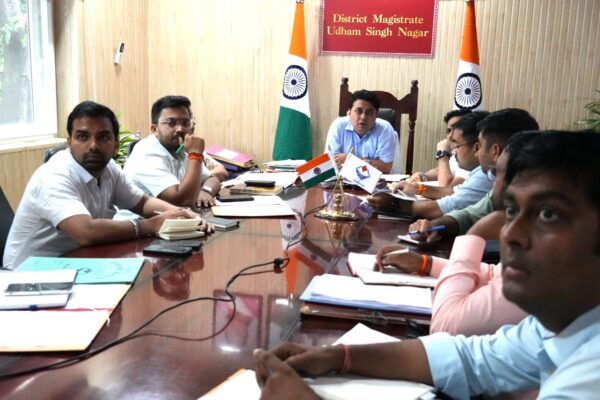 रुद्रपुर, 11 सितंबर 2025 – (समय बोल रहा) – जिलाधिकारी श्री नितिन सिंह भदौरिया ने आज कैंप कार्यालय में एक महत्वपूर्ण बैठक की अध्यक्षता की। इस बैठक का मुख्य उद्देश्य जिले में रेलवे विभाग से संबंधित विभिन्न लंबित परियोजनाओं की गहन समीक्षा करना था। बैठक में जिलाधिकारी ने परियोजनाओं की धीमी गति पर कड़ी नाराजगी व्यक्त की और संबंधित विभागों को जनहित को ध्यान में रखते हुए कार्यों में तेजी लाने के निर्देश दिए। यह बैठक इसलिए भी महत्वपूर्ण थी क्योंकि इसमें स्थानीय अधिकारियों के साथ-साथ रेलवे और राष्ट्रीय राजमार्ग प्राधिकरण (NH) के अधिकारी भी शामिल हुए, जिनमें से कई वर्चुअल माध्यम से जुड़े। काशीपुर-रामनगर आरओबी पर कड़ा रुख जिलाधिकारी ने विशेष रूप से काशीपुर-रामनगर आरओबी (रेलवे ओवर ब्रिज) के निर्माण कार्य की धीमी प्रगति पर अपनी नाराजगी व्यक्त की। उन्होंने राष्ट्रीय राजमार्ग (एनएच) के अधिकारियों को स्पष्ट निर्देश दिए कि वे इस परियोजना में तुरंत तेजी लाएं और कार्य को जल्द से जल्द पूरा करना सुनिश्चित करें। उन्होंने कहा कि यह परियोजना जनता के लिए बेहद महत्वपूर्ण है और इसकी गति में किसी भी तरह की ढिलाई बर्दाश्त नहीं की जाएगी। इसके साथ ही, उन्होंने उप जिलाधिकारी काशीपुर को निर्देश दिया कि वे इस आरओबी निर्माण कार्य की व्यक्तिगत रूप से निगरानी करें और प्रतिदिन की प्रगति रिपोर्ट सीधे जिलाधिकारी कार्यालय को भेजें। बैठक में सड़क की गुणवत्ता का मुद्दा भी उठा। जिलाधिकारी ने अधिकारियों को सर्विस रोड के कार्यों को दो दिन के भीतर पूरा करने का निर्देश दिया और कहा कि सभी सड़कों को गड्ढामुक्त किया जाए। उन्होंने जोर देकर कहा कि सड़कों की खराब हालत से जनता को परेशानी होती है, इसलिए इस पर तत्काल ध्यान दिया जाए। प्रमुख परियोजनाओं पर दिए निर्देश बैठक में कई अन्य महत्वपूर्ण परियोजनाओं पर भी चर्चा हुई और उनके समाधान के लिए ठोस निर्देश दिए गए: काशीपुर में प्रिया मॉल के पास अंडरपास: जिलाधिकारी ने अपर जिलाधिकारी और उप जिलाधिकारी काशीपुर को रेलवे अधिकारियों के साथ संयुक्त रूप से निरीक्षण कर प्रिया मॉल के पास रेलवे क्रासिंग पर अंडरपास बनाए जाने की संभावना पर रिपोर्ट देने को कहा। काशीपुर रेलवे स्टेशन पर जलभराव: इस गंभीर समस्या के समाधान के लिए उप जिलाधिकारी, अधिशासी अभियंता सिंचाई, लोनिवि (PWD) और नगर आयुक्त काशीपुर को एक संयुक्त सर्वे कर कार्य योजना प्रस्तुत करने का निर्देश दिया गया। बाजपुर में आरओबी: बाजपुर रेलवे क्रासिंग पर आरओबी निर्माण के लिए राष्ट्रीय राजमार्ग के अधिकारियों को उप जिलाधिकारी बाजपुर और रेलवे विभाग के अधिकारियों के साथ मिलकर प्रस्ताव तैयार करने को कहा गया। भूरारानी, रुद्रपुर में अंडरपास: जिलाधिकारी ने रेलवे अधिकारियों को भूरारानी, रुद्रपुर में निर्माणाधीन अंडरपास के कार्यों में तेजी लाने और उसे जल्द पूरा करने के निर्देश दिए। छतरपुर-मटकोटा मोटर मार्ग पर आरओबी: एनएच, लोनिवि और रेलवे विभाग के अधिकारियों को इस मार्ग पर आरओबी निर्माण के लिए कार्ययोजना बनाकर कार्यवाही करने के लिए कहा गया। अतिक्रमण और जनहित का मुद्दा जिलाधिकारी ने रेलवे विभाग को जनहित को सर्वोपरि रखने के निर्देश दिए। उन्होंने कहा कि सभी कार्य इस तरह से किए जाएं कि आम जनता को कम से कम असुविधा हो। इसके अलावा, उन्होंने रेलवे की भूमि पर हुए अतिक्रमण को लेकर भी सख्त रुख अपनाया। उन्होंने निर्देश दिया कि रेलवे और राजस्व विभाग संयुक्त रूप से निरीक्षण कर ऐसे सभी अतिक्रमणों को तुरंत हटाएं। खटीमा से मझोला के बीच रेलवे फाटक को खोलने के संबंध में भी चर्चा हुई। जिलाधिकारी ने उप जिलाधिकारी खटीमा और रेलवे अधिकारियों को मौके का निरीक्षण कर वहां रहने वाले लोगों की आवाजाही को ध्यान में रखते हुए एक विस्तृत रिपोर्ट प्रस्तुत करने का निर्देश दिया। उन्होंने चकरपुर खटीमा में अंडरपास में पानी के रिसाव को 15 अक्टूबर तक ठीक करने का भी समयबद्ध निर्देश दिया। बैठक में उपस्थित अधिकारीगण बैठक में प्रभागीय वनाधिकारी यूसी तिवारी, अपर जिलाधिकारी पंकज उपाध्याय, कौस्तुभ मिश्र, उप जिलाधिकारी मनीष बिष्ट, गौरव पाण्डेय, अभय प्रताप सिंह, तुषार सैनी, सीनियर सेक्शन इंजिनियर रेलवे काशीपुर यशवंत मीना, अखिलेश कुमार सहित अन्य अधिकारीगण मौजूद थे। डीआरएम इज्जतनगर भारत भूषण, उप जिलाधिकारी बाजपुर, पीडी एनएचएआई (NHAI) और अन्य संबंधित अधिकारी वर्चुअल माध्यम से इस बैठक में शामिल हुए। जिलाधिकारी ने सभी अधिकारियों को कार्यों में समन्वय बनाए रखने और जनता की समस्याओं को प्राथमिकता से हल करने की अपील की।