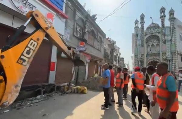 काशीपुर, 22 सितंबर 2025,(समय बोल रहा ) - काशीपुर के अल्ली खां में कल रात हुए भारी बवाल के बाद आज काशीपुर पुलिस और प्रशासन पूरी तरह से एक्शन में आ गया है। इस दौरान पुलिस ने आरोपियों की ताबड़तोड़ धरपकड़ की तो वहीं प्रशासन ने पूरे अल्ली खां इलाके में बुलडोजर चलाकर अवैध अतिक्रमण को ध्वस्त कर दिया। इस बड़ी कार्रवाई से जहां पूरे इलाके में हड़कंप मच गया, वहीं प्रशासन ने यह संदेश दिया है कि कानून तोड़ने वालों को बख्शा नहीं जाएगा। दरअसल, यह पूरा मामला कल रात उस समय शुरू हुआ जब 'आई लव मोहम्मद' की तख्तियां लेकर मुस्लिम समुदाय के लोग बिना किसी अनुमति के जुलूस निकालने लगे। पुलिस ने जब उन्हें रोकने की कोशिश की तो जुलूस में शामिल कुछ असामाजिक तत्वों ने पुलिसकर्मियों के साथ न केवल धक्का-मुक्की की, बल्कि उनकी गाड़ियों पर पथराव कर शीशे भी तोड़ दिए। इस घटना ने पूरे शहर में तनाव पैदा कर दिया था। पुलिस कप्तान ने संभाली कमान बवाल की सूचना मिलते ही जिले के पुलिस कप्तान मणिकांत मिश्रा ने खुद मोर्चा संभाला। आज सुबह वह भारी पुलिस बल के साथ अल्ली खां पहुंचे और स्थिति का जायजा लिया। उनकी मौजूदगी में पुलिस ने तुरंत आरोपियों की धरपकड़ का अभियान चलाया। इस दौरान पुलिस की कई टीमों ने मोहल्ले के चप्पे-चप्पे पर छापेमारी की। पुलिस की इस कार्रवाई से पूरे मोहल्ले में अफरा-तफरी का माहौल बन गया। गलियों में सन्नाटा पसर गया और लोग अपने घरों में दुबक गए। पुलिस ने कड़ी मशक्कत के बाद लगभग 14 लोगों को हिरासत में लिया है। पुलिस अधिकारियों के मुताबिक, इन सभी आरोपियों को पूछताछ के बाद आगे की कार्रवाई के लिए कोर्ट में पेश किया जाएगा। हालांकि, अभी भी इस घटना का मुख्य आरोपी पुलिस की गिरफ्त से बाहर है और उसे पकड़ने के लिए पुलिस लगातार दबिश दे रही है। पुलिस कप्तान ने स्पष्ट कर दिया है कि जब तक सभी आरोपी गिरफ्तार नहीं हो जाते, यह अभियान जारी रहेगा। अतिक्रमण पर चला प्रशासन का बुलडोजर पुलिस की कार्रवाई के साथ ही प्रशासन ने भी अपना सख्त रुख दिखाया। अल्ली खां में अवैध अतिक्रमण की शिकायतें लंबे समय से मिल रही थीं, लेकिन कल रात की घटना के बाद प्रशासन ने कोई ढील नहीं दी। आज सुबह से ही प्रशासनिक अधिकारी भारी सुरक्षा के साथ बुलडोजर लेकर अल्ली खां चौराहे पर पहुंच गए। वहां से थाना साबिक तक पूरे रास्ते में बुलडोजर चलाकर हर उस दुकान और मकान के आगे किए गए अतिक्रमण को ध्वस्त कर दिया गया, जो नाली के ऊपर किया गया था। इस कार्रवाई के दौरान कई दुकानदारों और मकान मालिकों में हड़कंप मच गया। कुछ लोगों ने इसका विरोध करने की कोशिश की, लेकिन भारी पुलिस बल की मौजूदगी के कारण उनकी एक न चली। प्रशासन का कहना है कि यह कार्रवाई किसी जाति या धर्म के खिलाफ नहीं है, बल्कि कानून का उल्लंघन करने वाले हर व्यक्ति के खिलाफ है। कानून व्यवस्था बनाए रखना प्राथमिकता एक वरिष्ठ पुलिस अधिकारी ने बताया, "किसी भी सूरत में कानून व्यवस्था से खिलवाड़ बर्दाश्त नहीं किया जाएगा। कल की घटना दुर्भाग्यपूर्ण थी और हम दोषियों को उनके किए की सजा जरूर दिलाएंगे। पुलिस उन सभी लोगों पर नजर रखे हुए है, जिन्होंने माहौल खराब करने की कोशिश की।" आज की इस संयुक्त कार्रवाई ने यह साबित कर दिया है कि उत्तराखंड में कानून का राज कायम है और कोई भी व्यक्ति इसे चुनौती नहीं दे सकता। पुलिस और प्रशासन ने एक मजबूत संदेश दिया है कि शांति और सद्भाव को बिगाड़ने वालों के खिलाफ सख्त कार्रवाई की जाएगी। इलाके में शांति बनाए रखने के लिए अतिरिक्त पुलिस बल भी तैनात किया गया है और गश्त बढ़ा दी गई है।